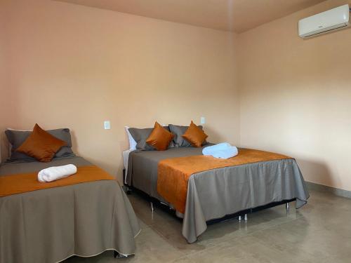sypialnia z 2 łóżkami i stołem w obiekcie Chalés Cantin da Serra - Serra da Canastra/MG w mieście São Roque de Minas