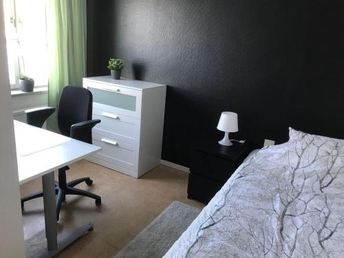 a bedroom with a bed and a desk and a white desk at Hammarö Vandrarhem in Hammarö