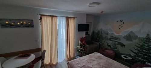 a living room with a christmas tree on the wall at Snowman Studio Apartment Jahorina in Jahorina