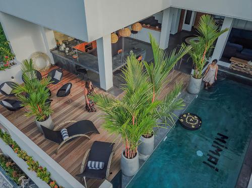 an overhead view of a pool with palm trees and chairs at Villa Mimpi Bali in Jimbaran