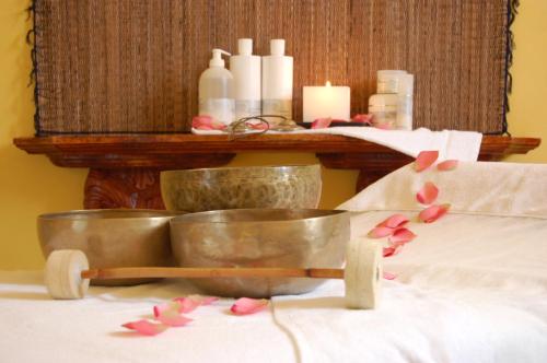 a table with two bowls and candles and pink flowers at Relais La Colombara Spa & Wellness in Travo
