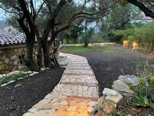 a stone path in a yard with trees and a fence at Holiday Home Ruby in Sveti Jakov
