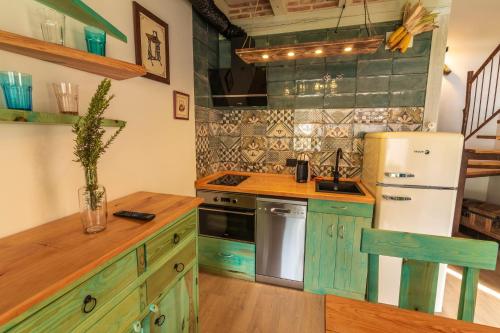 a kitchen with green cabinets and a white refrigerator at La Galiana loft nature in Casarejos