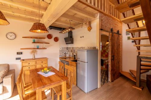 a kitchen with a wooden table and a refrigerator at La Galiana loft nature in Casarejos