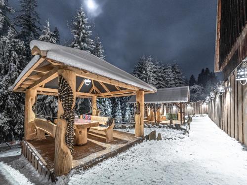 a wooden gazebo in the snow at night at Zagroda Krowiarki Chochołów in Chochołów