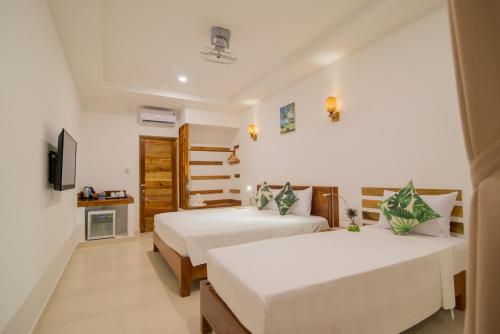 pokój hotelowy z dwoma łóżkami i telewizorem w obiekcie Palma Resort w Duong Dong