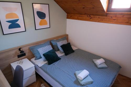 a small bedroom with a blue bed with pillows at Sunrise Apartments in Niš