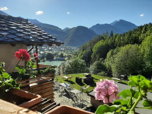 a balcony with a view of a river and mountains at L'Abreny in Brusson
