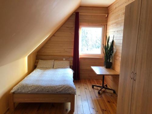 mały pokój z łóżkiem i oknem w obiekcie Forest house Einblūti w mieście Avotkalni