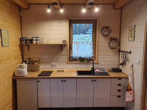 a kitchen with a counter and a sink and a window at Domki Widokówka in Wysowa-Zdrój