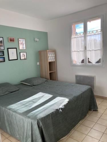 ein Schlafzimmer mit einem großen Bett und einem Fenster in der Unterkunft T2 Classé 2* calme au coeur du village provençale in Gréoux-les-Bains