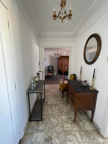 a living room with a table and a mirror at Appartement climatisé F3 proche plage port et aéroport in Ajaccio
