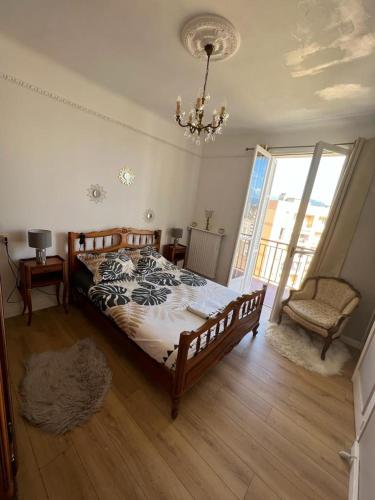 a bedroom with a large bed and a chandelier at Appartement climatisé F3 proche plage port et aéroport in Ajaccio