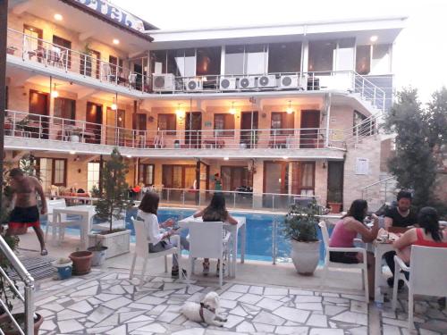 a group of people sitting around a pool in a hotel at Alida Hotel in Pamukkale