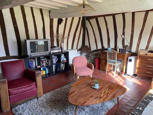 un salon avec un canapé et une table dans l'établissement Belle Longère normande, cheminée et jardin arboré, à Canville-les-Deux-Églises