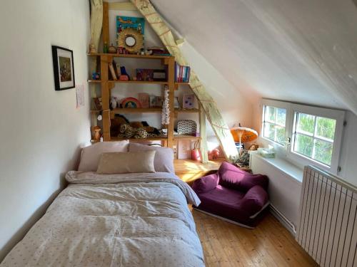 a bedroom with a bed and a couch in it at Belle Longère normande, cheminée et jardin arboré in Canville-les-Deux-Églises