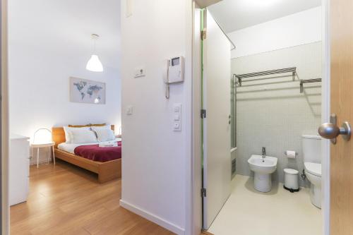 - une salle de bains avec toilettes et un lit dans une chambre dans l'établissement Vita Portucale ! Charming Loft with Garage, à Lisbonne
