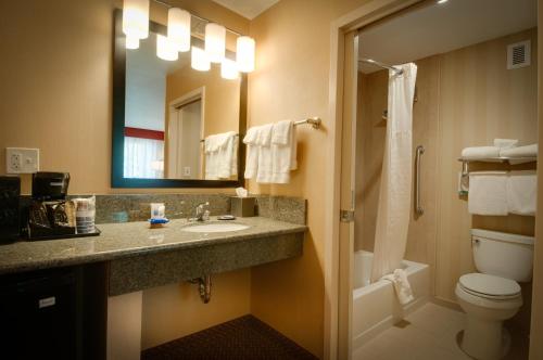 a bathroom with a sink and a toilet and a mirror at Best Western Plus Rancho Cordova Inn in Rancho Cordova