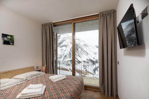 a bedroom with a bed with a view of a mountain at Casa Noemi in Livigno