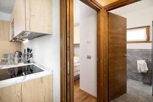 a kitchen with white walls and a wooden door at Casa Noemi in Livigno