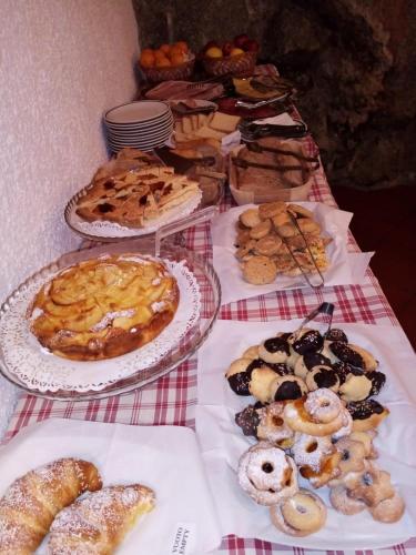 a table filled with different types of pastries on plates at Hotel Ottoz Meublé in Courmayeur