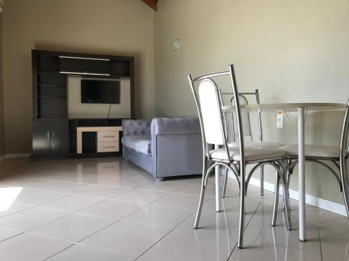 a living room with a table and chairs and a couch at Hotel Morada Del Este in Canoas