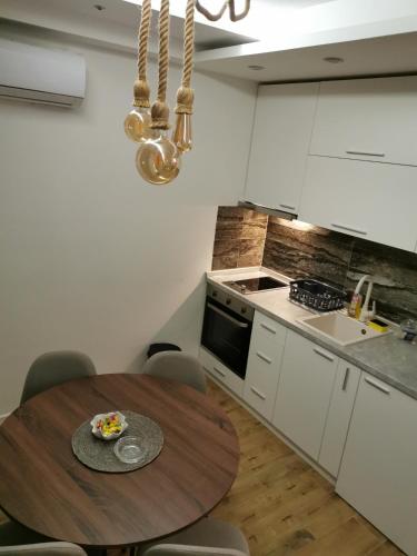 a kitchen with a wooden table in a room at Apartman Hill in Mirijevo