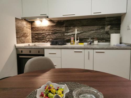 a kitchen with a table with a bowl of vegetables on it at Apartman Hill in Mirijevo