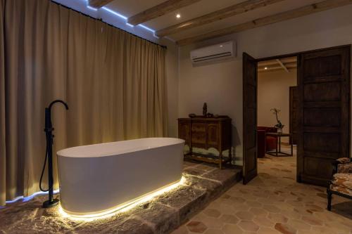 La grande salle de bains est pourvue d'une baignoire éclairée. dans l'établissement Casa 1810 Parque Hotel Boutique, à San Miguel de Allende