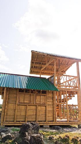 a wooden hut with a green roof on a field at Pachingo Tatacoa Desert in La Victoria