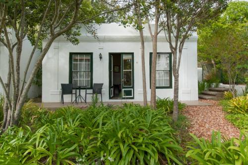 a white house with trees in front of it at Hotel Roosje van de Kaap in Swellendam