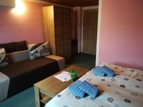a room with a bed and a table and a couch at Pension Krista in Kraslice