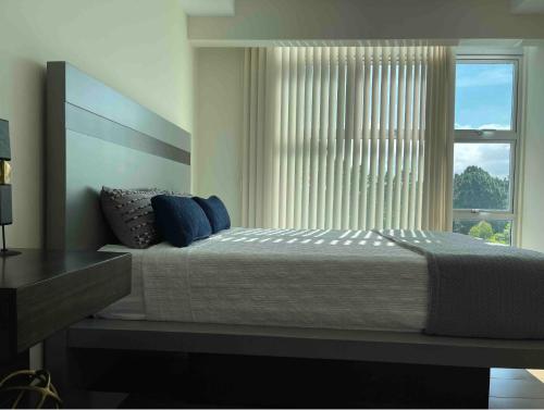 ein Schlafzimmer mit einem großen Bett und einem Fenster in der Unterkunft Lovely Apartment near Costa Rica airport in Heredia