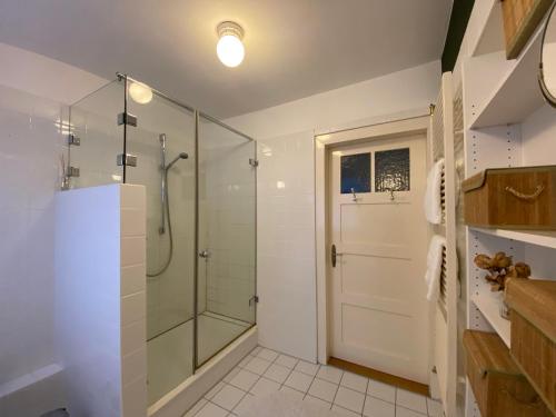 baño con ducha y puerta de ducha de cristal en Ferienhaus Waldglück, en Calw