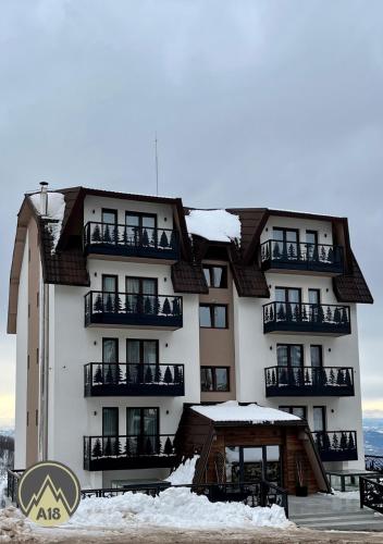a large white building with snow on it at Lux Apartman A18 & SPA Centar in Kopaonik