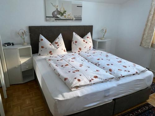 een slaapkamer met een bed met witte lakens en kussens bij Landhaus Appartement Kofler Ferienwohnungen,Zimmer in Maurach