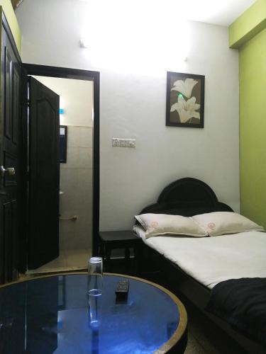 a room with two beds and a glass table at Hotel Hoque Tower International in Chittagong