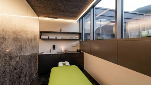 a bathroom with a green bench in a room at die berge lifestyle-hotel Sölden in Sölden