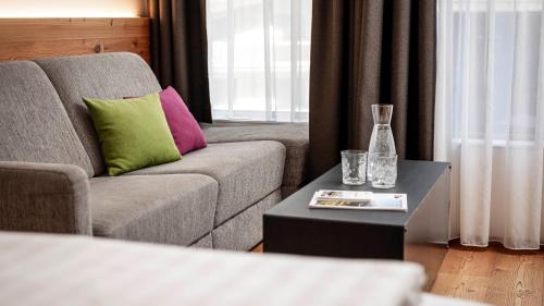 a living room with a couch and a table with a vase at die berge lifestyle-hotel Sölden in Sölden
