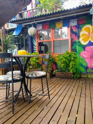 a table and two chairs on a wooden deck at Hostel do Morro in Florianópolis