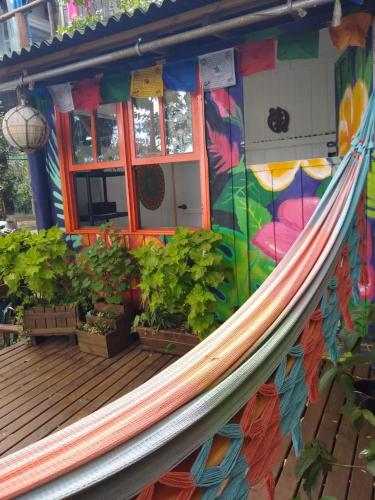 a hammock on a deck in front of a building at Hostel do Morro in Florianópolis