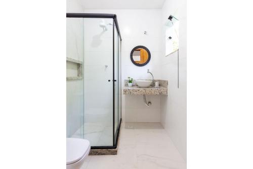 布希奧斯的住宿－Arpoador Apts Praia & Piscina - Buzios Rentals，浴室设有玻璃淋浴间和水槽