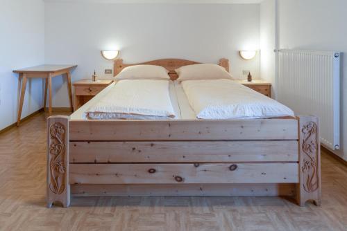 a bedroom with a wooden bed with two night stands at Apartments UDERA in Selva di Val Gardena