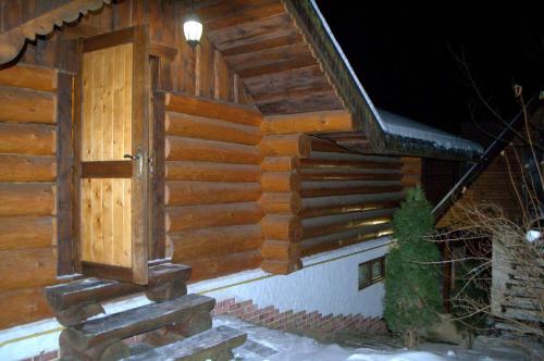 a wooden cabin with a door on the side of it at U Druziv in Polyana