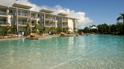 a swimming pool in front of a large building at Peppers Salt Resort & Spa - Lagoon pool access 2 br spa suite in Kingscliff