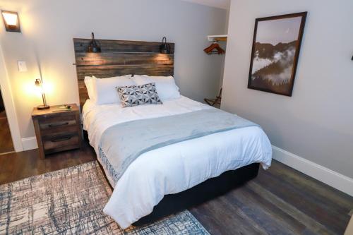 a bedroom with a large bed and a night stand at Gunstock Inn & Suites in Gilford