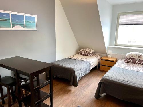 a room with two beds and a table and a window at Hostel Ingeri in Viljandi