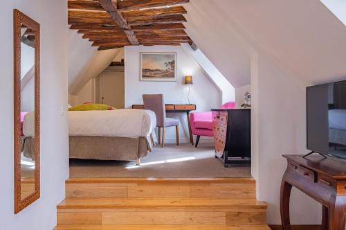 a bedroom with a bed and a table and a television at Auberge du Bon Laboureur Chenonceaux in Chenonceaux