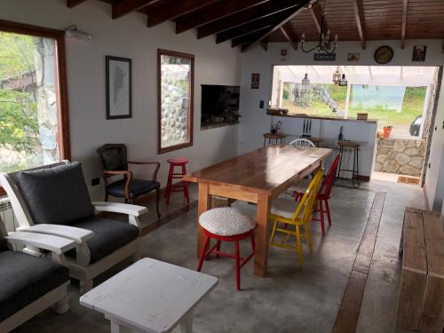 sala de estar con mesa de madera y sillas en Villa de los Ñires en Ushuaia