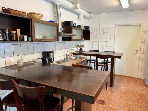 - une cuisine avec des tables et des chaises en bois dans la chambre dans l'établissement Hostel Ingeri, à Viljandi